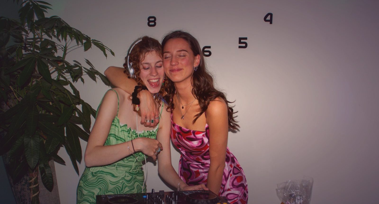 Cleo en Laura arm in arm achter de Pioneer DJ-draaitafel op een feest